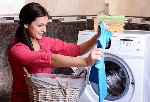 Woman pulls things out of a washing machine