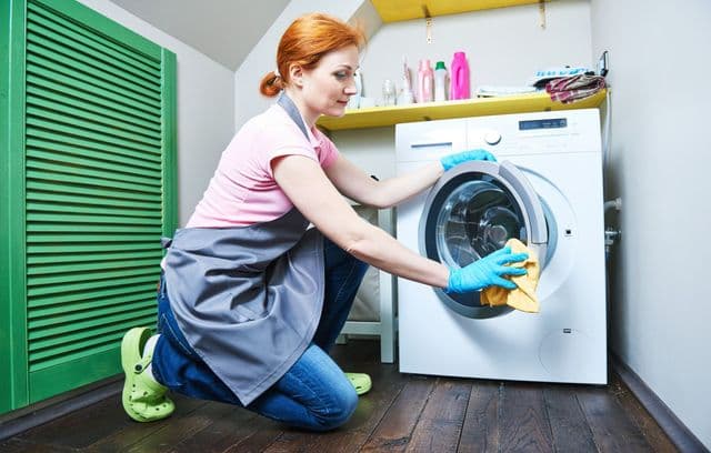 Fille nettoie une machine à laver