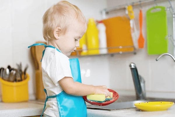 El niño lava los platos