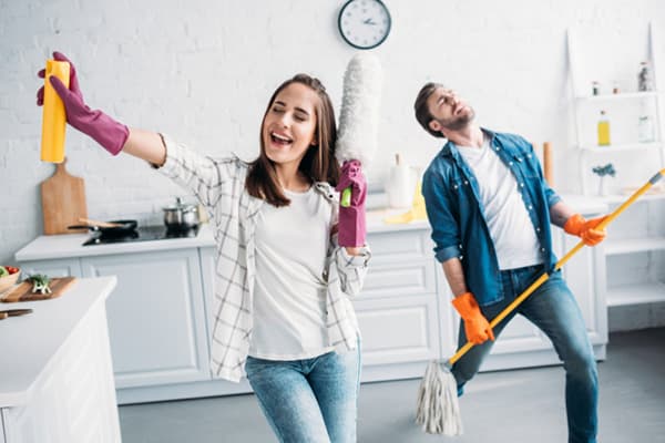 Đôi vợ chồng trẻ vui vẻ khi dọn dẹp.