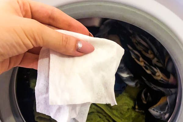 Femme met une serviette humide dans une machine à laver