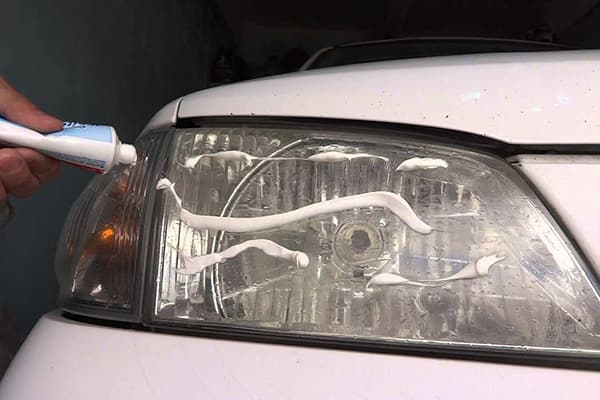 Zobu pastas uzlikšana uz automašīnas lukturiem