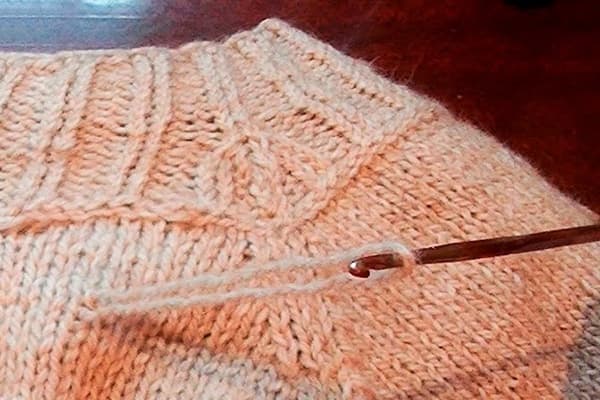 Piumino su un maglione lavorato a maglia