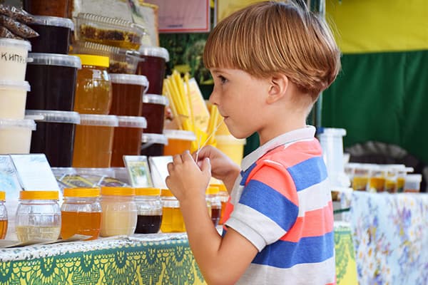 Dreng smager honning på messen